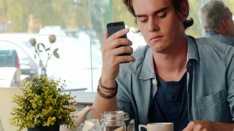 Casual man using touch screen mobile phone in cafe. Stock Footage 199634292
