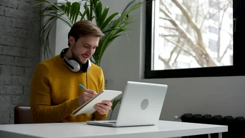 Casual man working at business document and checking the file on his laptop Video stock 229777712
