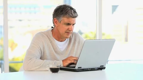 Casual middle aged man working on a laptop Stock Footage 1097205