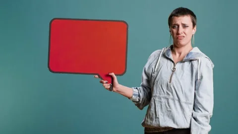Casual person presenting an empty speech bubble sign in studio Stock Footage 318169453