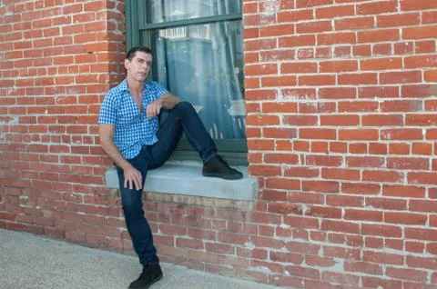 Casual pose in the window sill Stock Photos