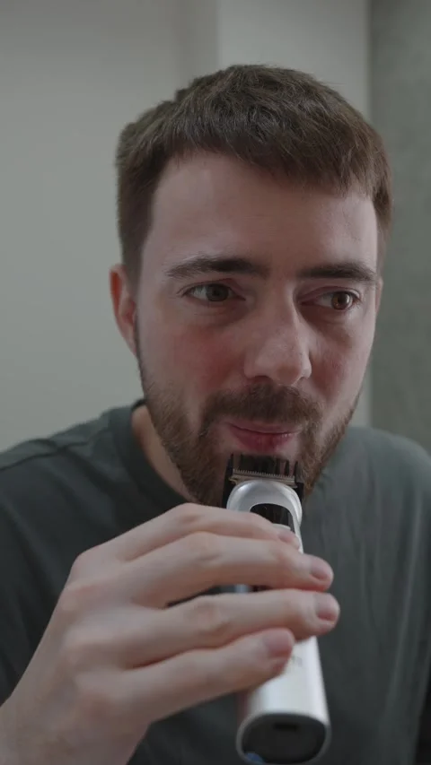 Casual scene of man exploring grooming appliance for first time Stock-Footage 333332113
