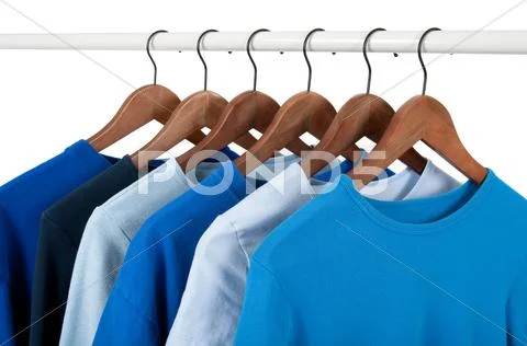 Casual shirts on hangers, different tones of blue Stock Photos