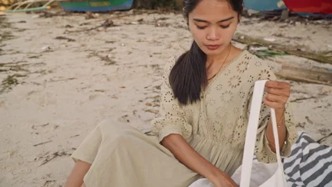 Casual skincare application on sandy beach during daytime. Woman diligently Stock Footage 341663839