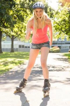 Casual smiling blonde inline skating Stock Photos