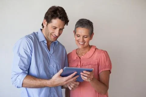 Casual smiling business team looking at tablet pc together Stock Photos