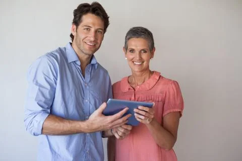 Casual smiling business team looking at tablet pc together Stock Photos