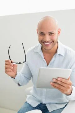 Casual smiling young man using digital tablet Stock Photos