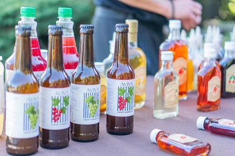 A casual table display at a fair, showcasing various bottles of alcoholic b.. 스톡 사진