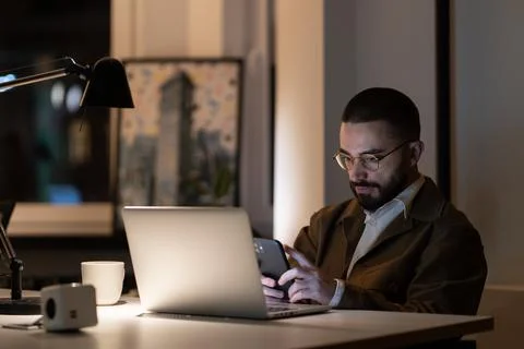 Casual web designer or programmer guy working alone in office late at night 写真素材