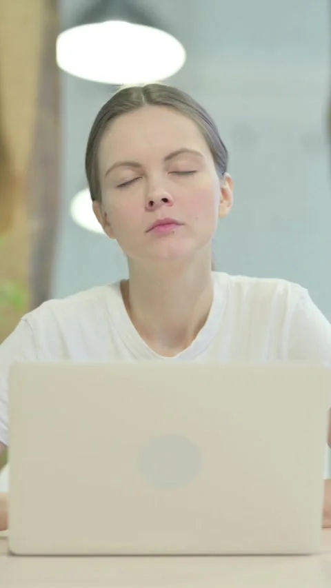 Casual Woman Looking at Camera while using Laptop, vertical video 動画素材 329107510