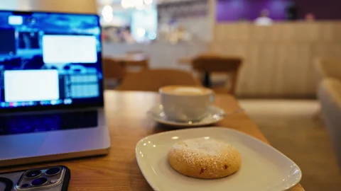 Casual work setup with laptop and biscuit, Reel footage of cafe with laptop and Stock Footage 319192267
