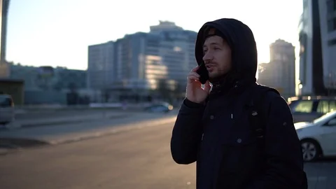 Casual young man with backpack talking on mobile phone in the city. Stock Footage 93336616