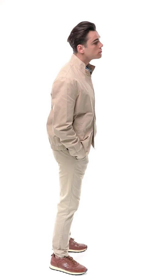 Casual young man with hands in pockets looking forward and behind, being Stock Footage 304829876
