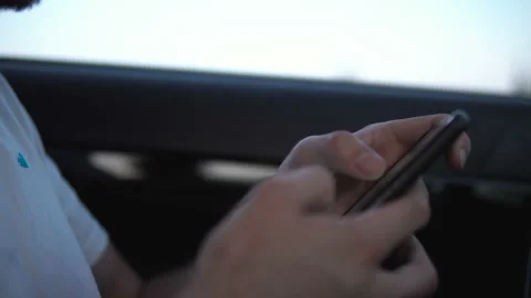 Casual young man using smartphone in a car. Stock Footage 116429561