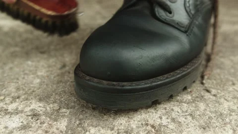 Casually Cleaning Black Leather Boots with Brush and Paste Stock-Footage 137315732