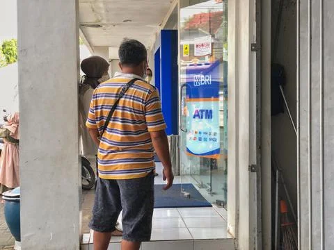 A casually dressed man standing in line at a Bank Rakyat Indonesia Stock Photos