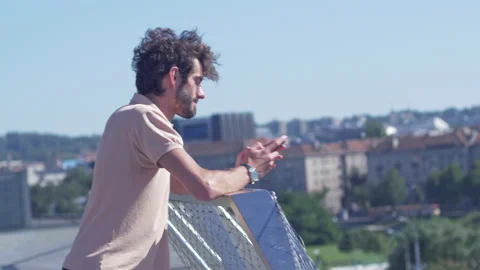 Casually dressed man typing on a phone while waiting for a meeting outdoor Stock-Footage 132854014