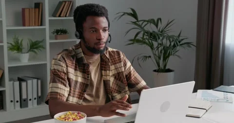 Casually dressed man working from home, sitting at the desk, working on laptop. Stock Footage 253825591