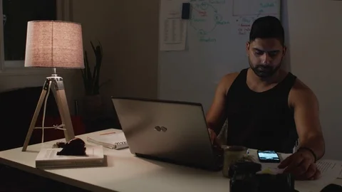 Casually Dressed Man Works Back Late in Dark Office at Night, Uses Phone Stock Footage 108892072