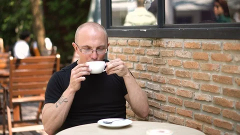 Casually Dressed Vegan Caucasian Man Drinking Soy Latte Outdoors at Hip Cafe Stock Footage 102158236