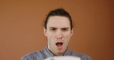 Casually Dressed Young Man Sneezing into White Tissue Stock Footage 127679710