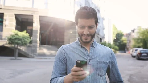 Casually Dressed Young Stylish Man Standing in the City.Using his Mobile Device Video stock 92596350