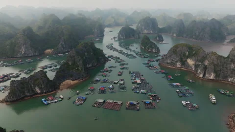 Cat Ba Vietnam approach between limestone cliffs past floating platforms and Stock Footage 332944077