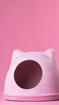 Cat bed in the shape of a pink house on a plain pink background Stock Photos