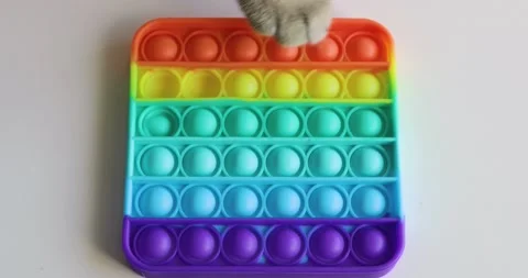 Cat playing with Popit push pop bubble fidget toy. topview of playing a popular Stock Footage 154503007