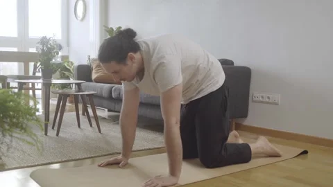 Cat posture. Young male doing yoga and stretching at home Stock Footage 274500675