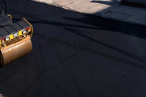CAT road roller compacting fresh asphalt in Brooklyn Photos