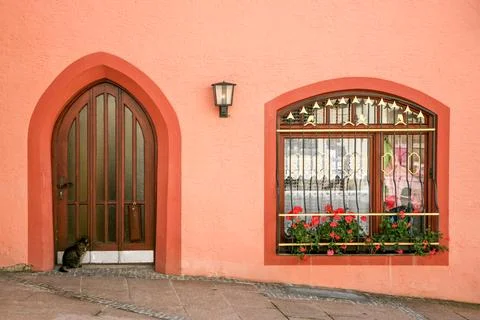 A cat is sitting on the sidewalk in front of a building in Fussen Germany Stock Photos