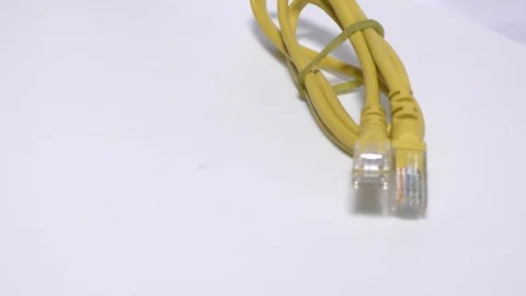 Cat5 yellow cable on rotation wheel and moving on white Video stock 111887703