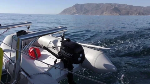 Catalina in view 1 catamaran with a fully loaded shore dinghy dangling Stock Footage 67959000