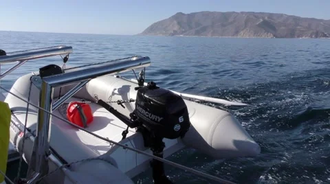Catalina in view 2 catamaran with a fully loaded shore dinghy dangling Stock Footage 67957276