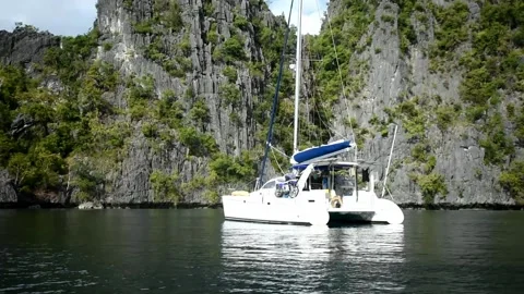 Catamaran anchor in front of Cliff Stock Footage 149649313