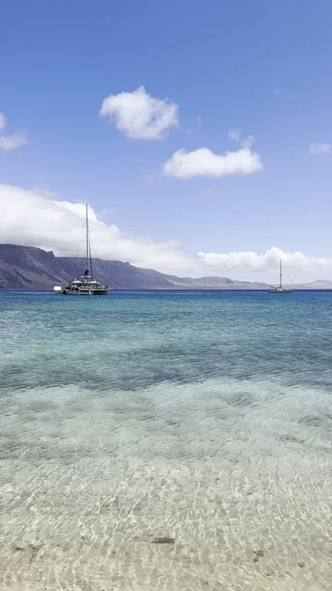 Catamaran floating on Crystal Clear Waters at Playa La Francesa of La Graciosa Stock Footage 320123098