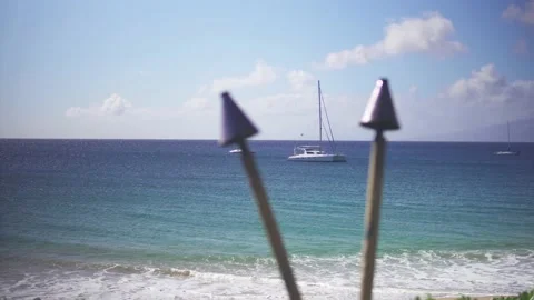 Catamaran framed between two tiki torches in Maui Hawaii waters. Stock Footage 135228483