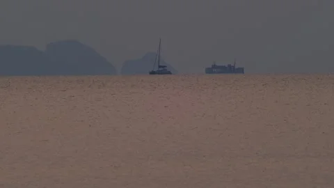 Catamaran Overtaking Ferry at Sea During Tropical Twilight Видео 333812803