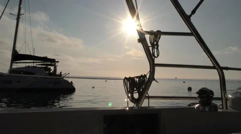 Catamaran seen through ropes on boat in early morning sun on mooring balls  Stock Footage 67520692
