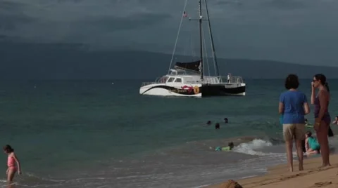 Catamaran ship in ocean, people on sunny beach, blue sky, Hawaii Stock Footage 57463560
