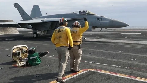 Catapult officers signal to F/A-18 pilot for take off aboard USS Abraham Lincoln Stock Footage 107716398