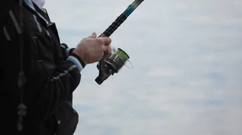 Catching fish by a fisherman using spinning reels on a lake in countryside Stock Footage 8930892