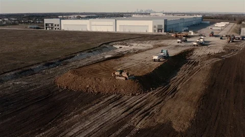 A Catepillar brand backs up after pushing a load of soil to the edge of Stock Footage 123563127