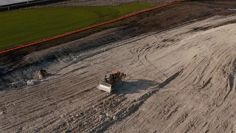 A Catepillar brand multi terrain loader drives in reverse while compacting Stock Footage 123563122