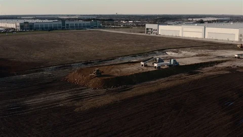 A Catepillar tractor loader pushes the dirt while building a solid Stock Footage 123563101