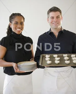 Caterers Holding Plates And Tray Of Food