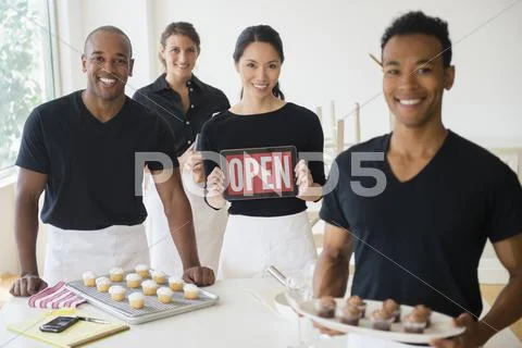Caterers Smiling Together With Food And Open Sign In Event Space