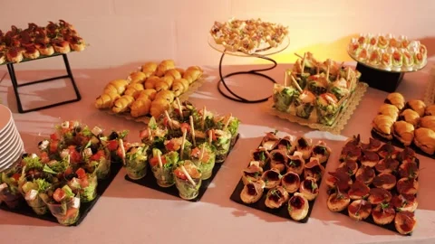 Catering buffet table with assorted appetizers and finger food at event Stock Footage 324570738